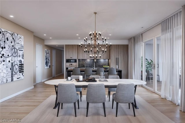 dining room featuring a chandelier, recessed lighting, baseboards, and light wood finished floors