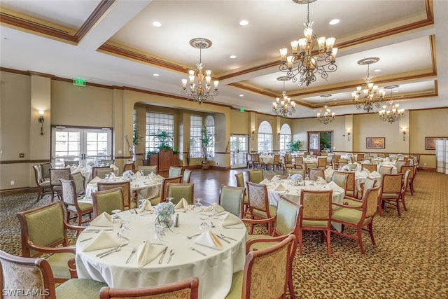 carpeted dining room with an inviting chandelier, ornamental molding, and a tray ceiling