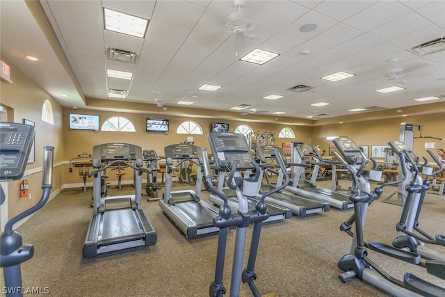 exercise room with ceiling fan, carpet floors, and a paneled ceiling