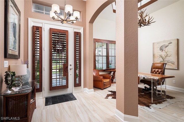 entryway with light hardwood / wood-style flooring and a notable chandelier