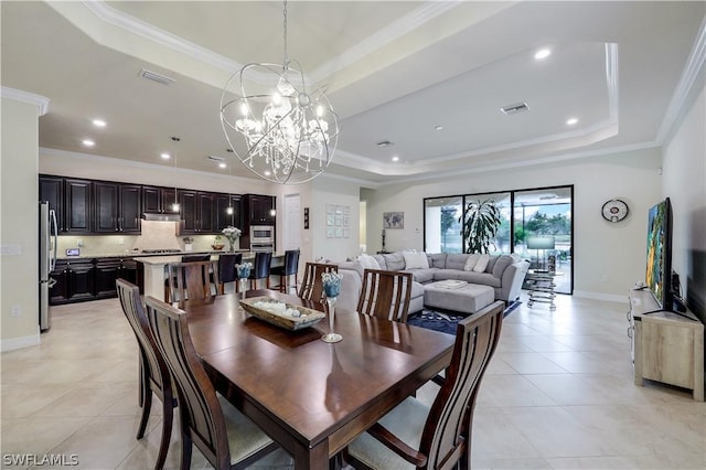 tiled dining area featuring a chandelier, ornamental molding, and a raised ceiling