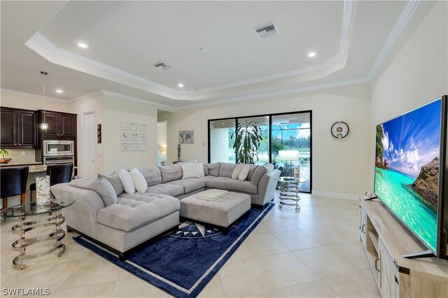 tiled living room featuring a tray ceiling and crown molding