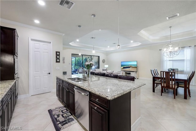 kitchen with pendant lighting, an island with sink, sink, stainless steel dishwasher, and a raised ceiling