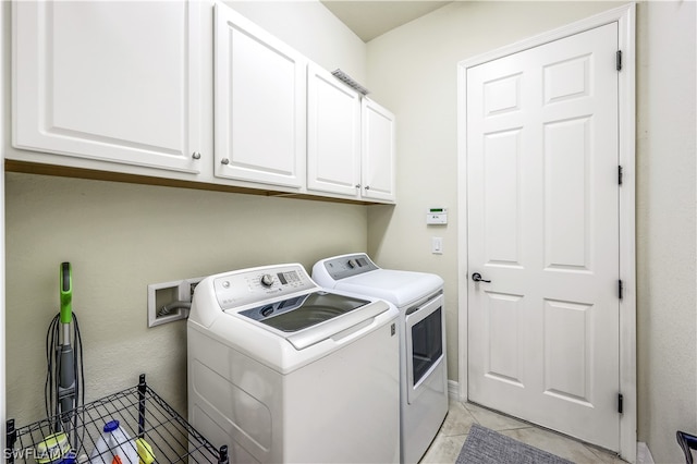 clothes washing area featuring hookup for a washing machine, cabinets, light tile floors, and washing machine and clothes dryer