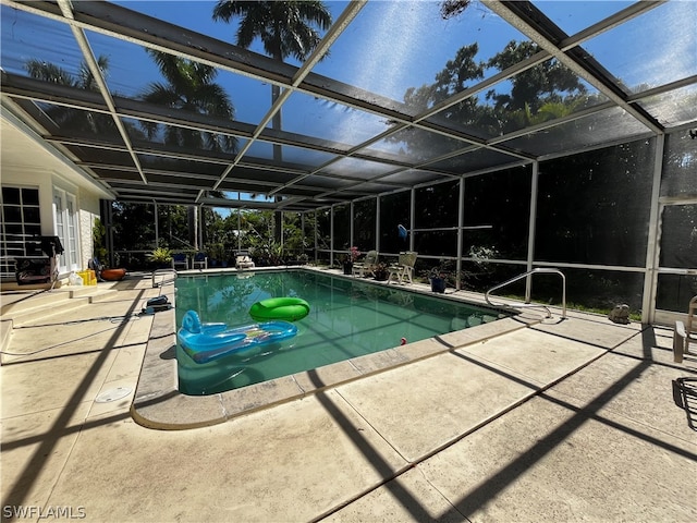 view of pool with a patio area and glass enclosure