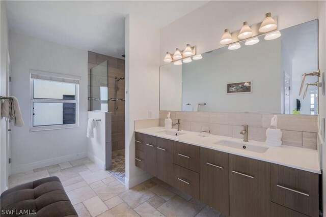 bathroom with decorative backsplash, tiled shower, and vanity