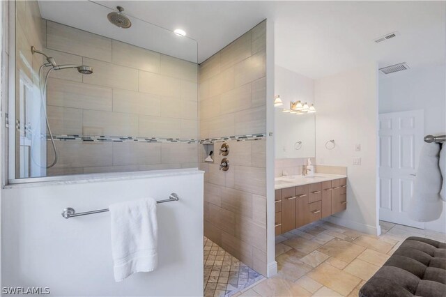 bathroom with vanity and a tile shower