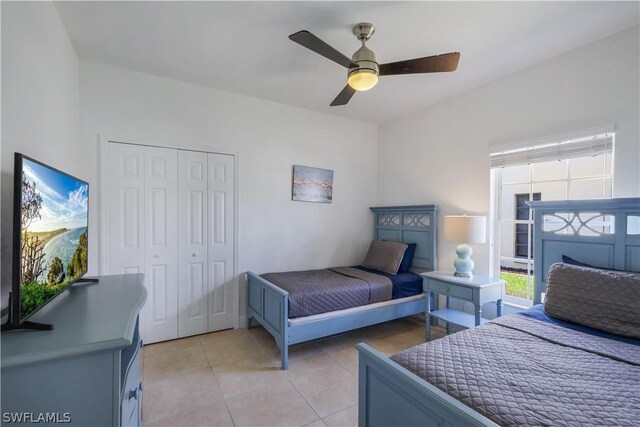 tiled bedroom with ceiling fan and a closet