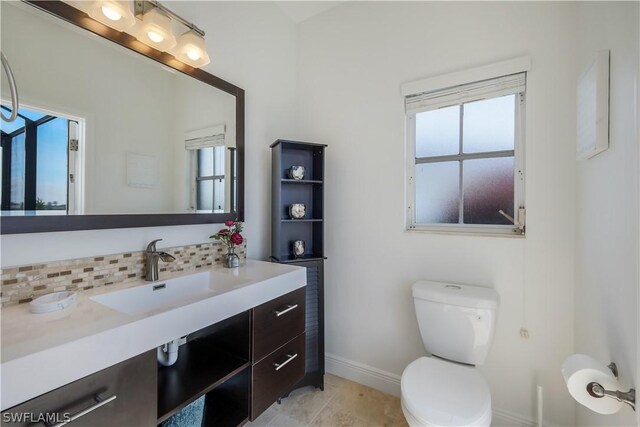 bathroom featuring tile patterned floors, decorative backsplash, vanity, and toilet