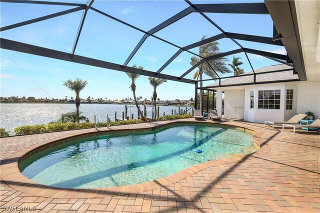 view of swimming pool with glass enclosure, a patio area, and a water view