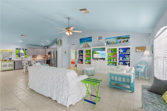 living room with ceiling fan, light tile patterned flooring, and vaulted ceiling