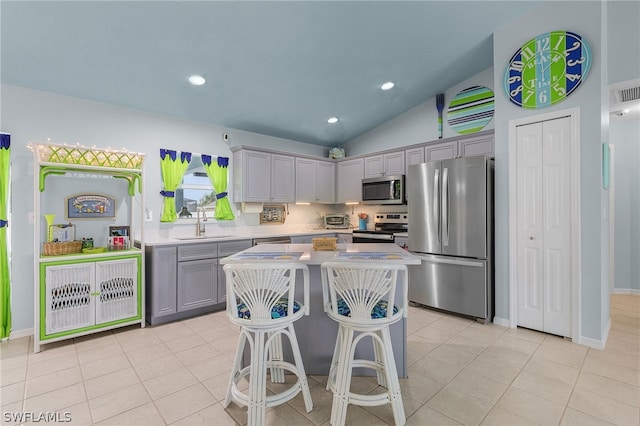 kitchen featuring gray cabinets, sink, stainless steel appliances, and lofted ceiling