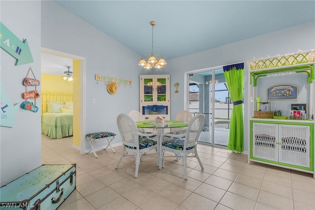 tiled dining room featuring ceiling fan with notable chandelier and lofted ceiling