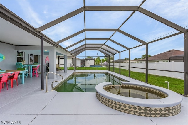 view of swimming pool featuring glass enclosure, a yard, an in ground hot tub, and a patio