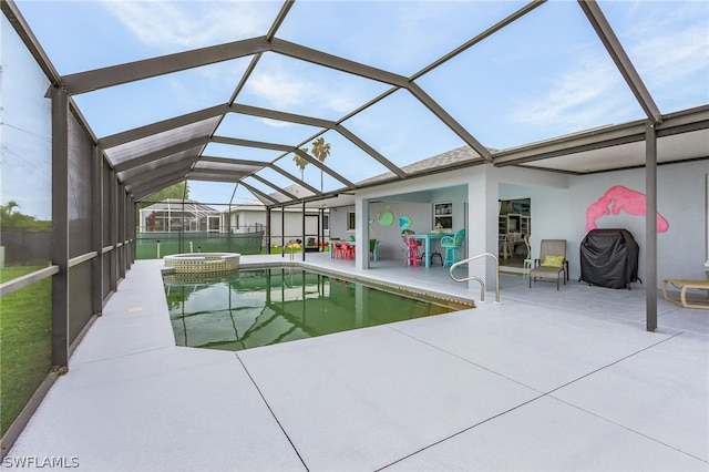 view of pool with an in ground hot tub, a patio, and glass enclosure