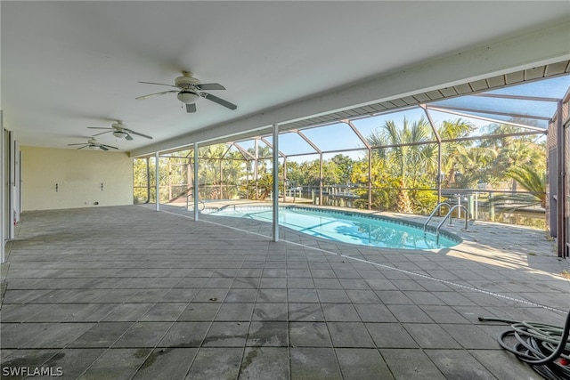 view of swimming pool with ceiling fan, a patio area, and a lanai