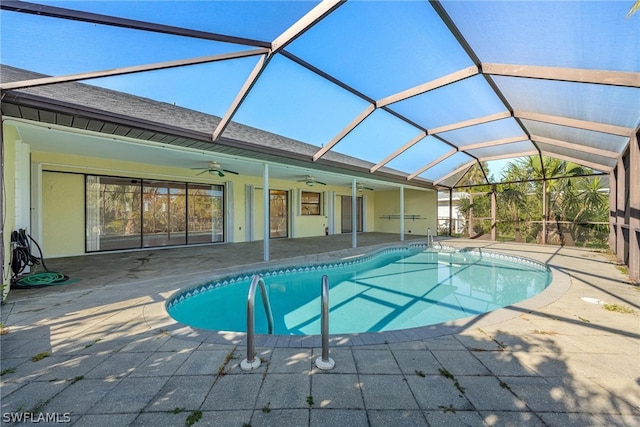 view of swimming pool with ceiling fan, a patio area, and glass enclosure