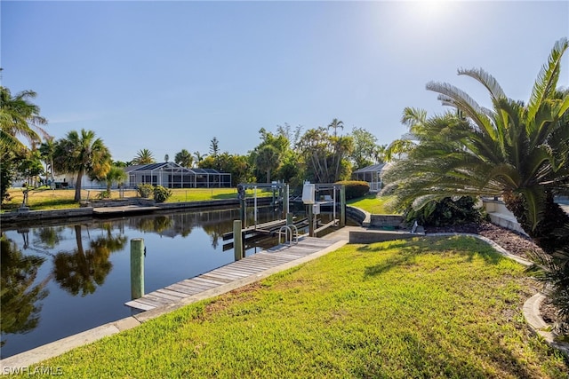 view of dock with a water view and a lawn