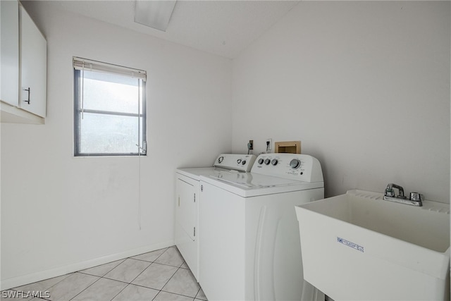 washroom featuring washing machine and dryer, sink, and light tile patterned floors