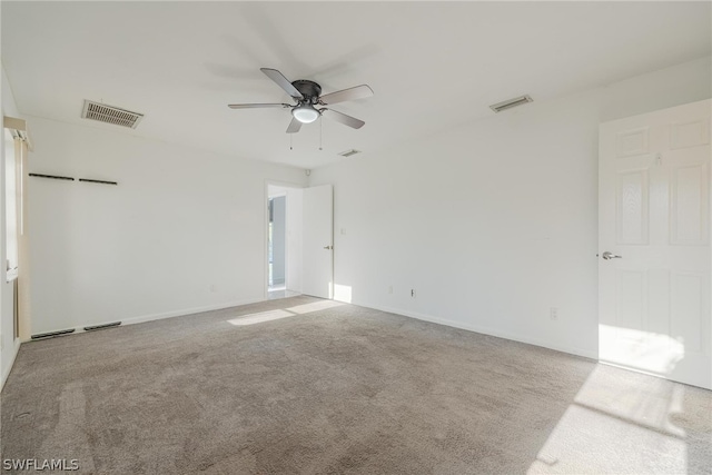 empty room featuring ceiling fan and light colored carpet