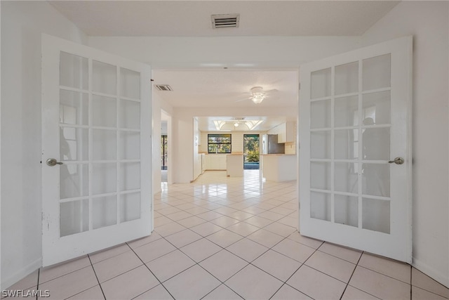 empty room featuring french doors and light tile patterned floors