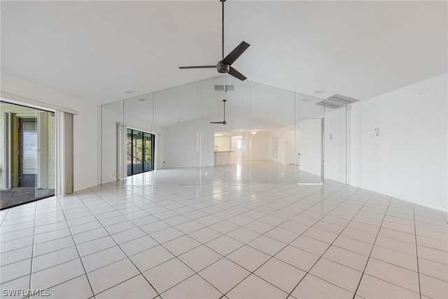 empty room featuring ceiling fan, light tile patterned floors, and vaulted ceiling