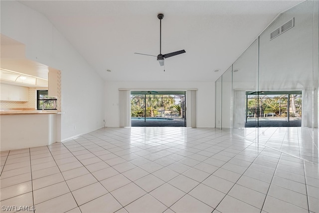 unfurnished living room featuring ceiling fan, light tile patterned floors, and high vaulted ceiling