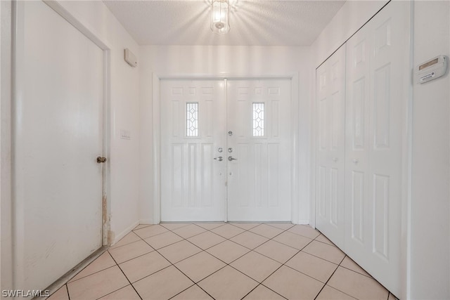 tiled entryway with a textured ceiling