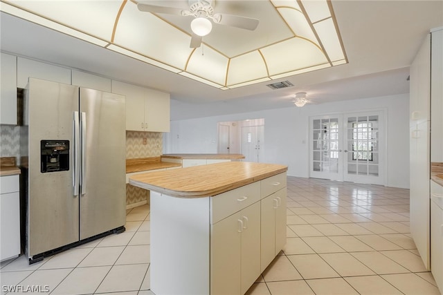 kitchen featuring white cabinets, stainless steel fridge with ice dispenser, decorative backsplash, and french doors