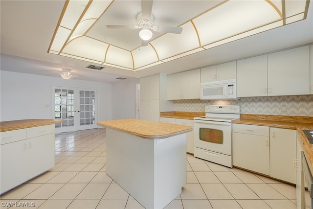 kitchen featuring wooden counters, french doors, white appliances, white cabinets, and a center island