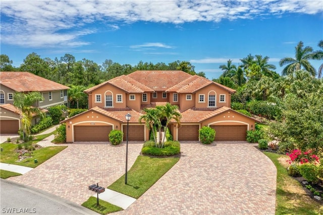 mediterranean / spanish-style home with a garage and a front lawn