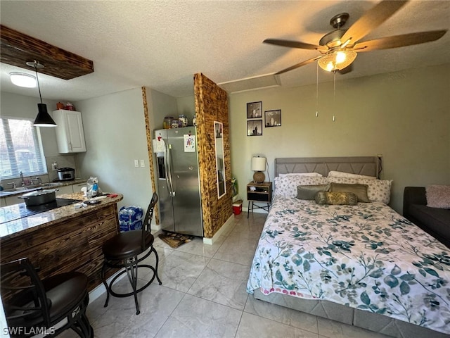 tiled bedroom featuring stainless steel fridge with ice dispenser, ceiling fan, sink, and a textured ceiling