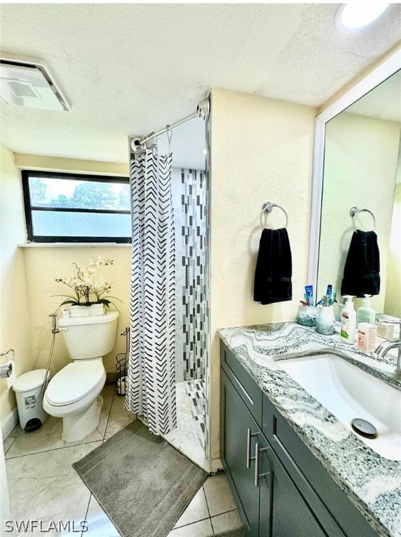 bathroom with tile patterned flooring, a shower with curtain, toilet, and vanity