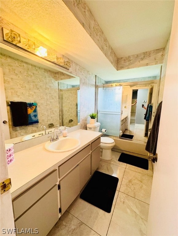 bathroom with tile patterned floors, vanity, a textured ceiling, and toilet