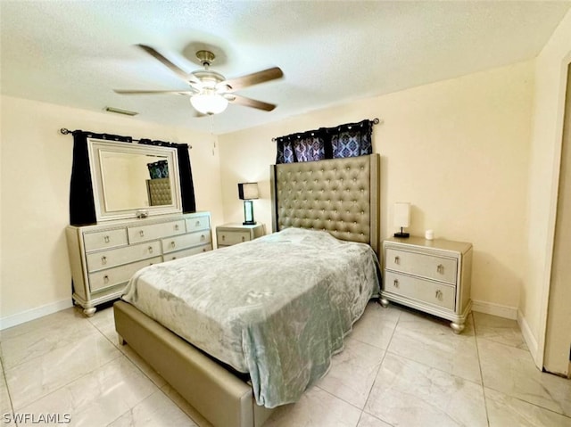 tiled bedroom with a textured ceiling and ceiling fan