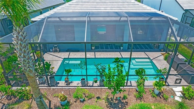 back of house with glass enclosure and a patio area