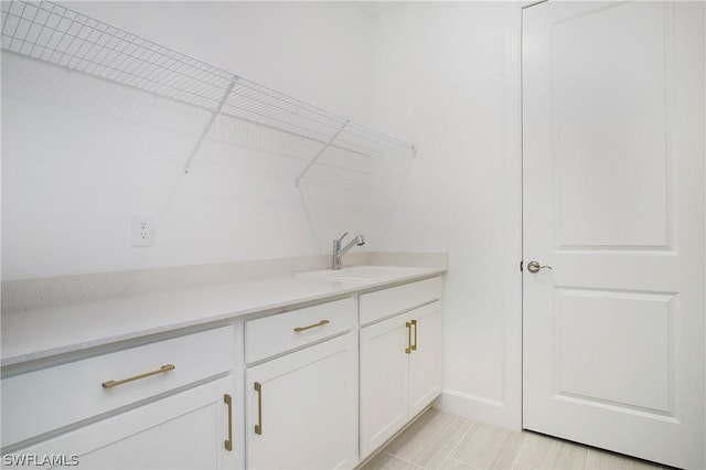 clothes washing area with sink and light tile patterned floors