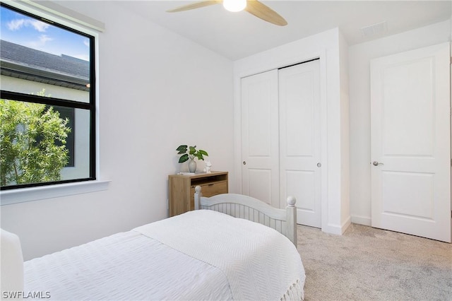 carpeted bedroom featuring ceiling fan and a closet