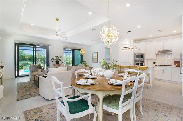 dining space with a chandelier and a tray ceiling