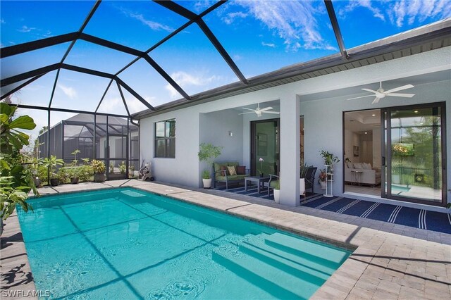 view of swimming pool with a patio area, ceiling fan, and glass enclosure