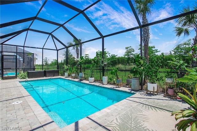 view of swimming pool with glass enclosure and a patio area