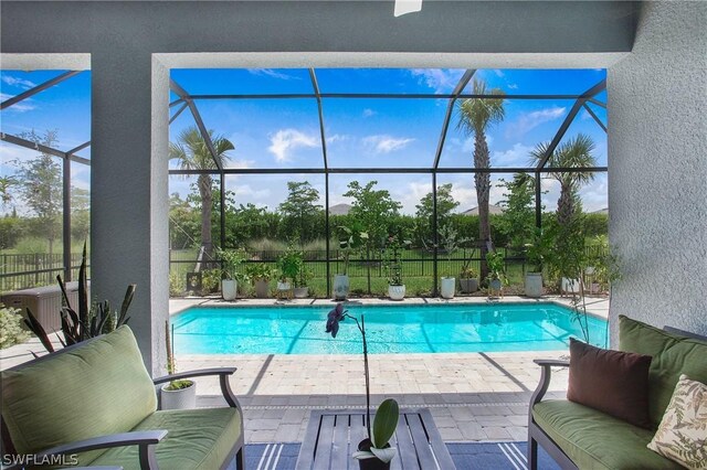 view of swimming pool with a patio area and glass enclosure