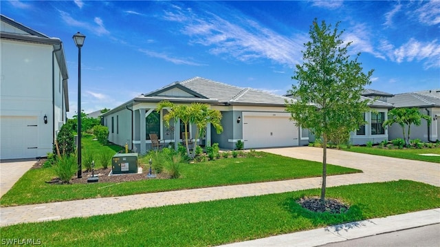 view of front of house featuring stucco siding, a front lawn, an attached garage, and driveway