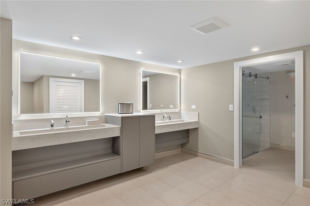 bathroom featuring tile patterned flooring, vanity, and a shower with door