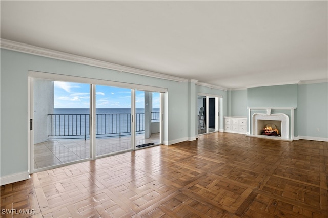 unfurnished living room featuring crown molding, a water view, and parquet flooring