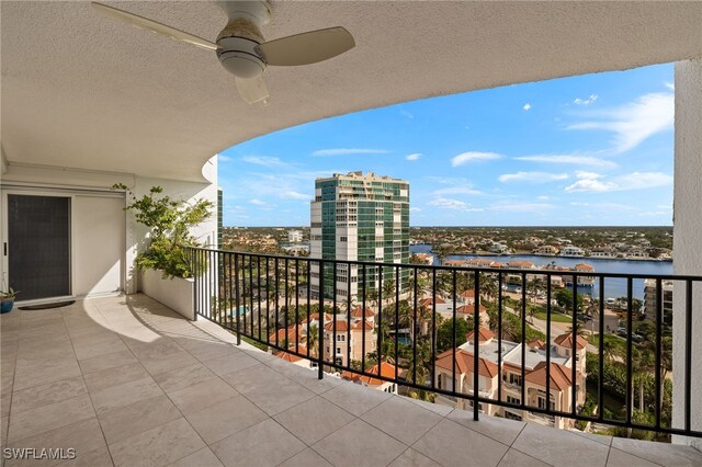 balcony featuring ceiling fan and a water view