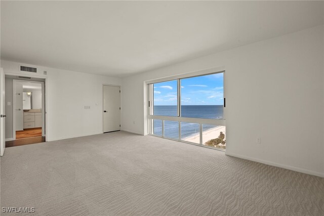 spare room with carpet floors and a water view