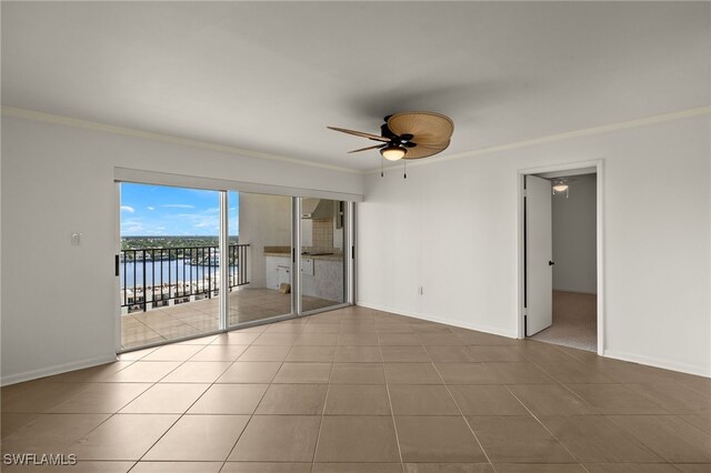 tiled spare room with ceiling fan, a water view, and crown molding