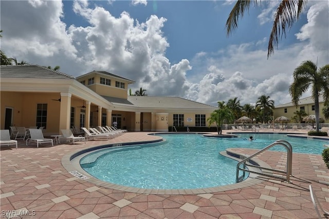 view of swimming pool with ceiling fan and a patio area