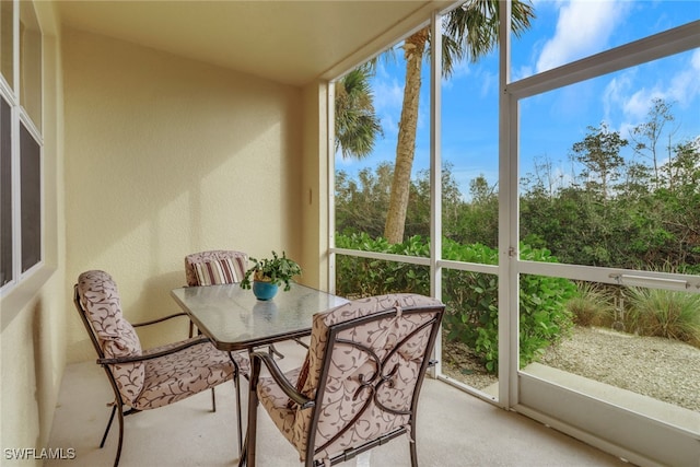14573 Abaco Lakes Dr Unit 102, Fort Myers, FL 33908 - sunroom with carpet, outdoor dining area, and a textured wall